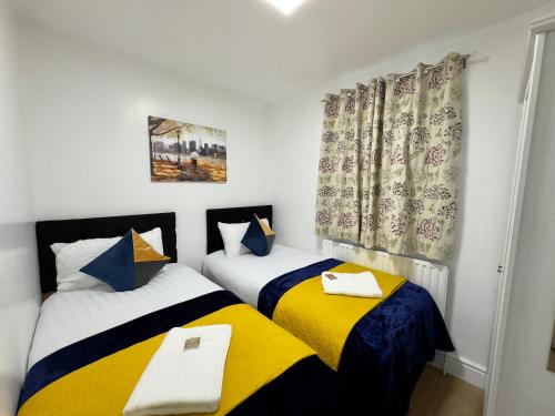 duas camas num pequeno quarto com cortinas em 4 Bedrooms, 2 Bathrooms, Parking, Spacious House em Londres