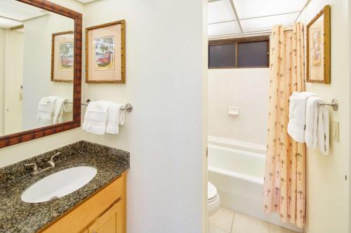 a bathroom with a sink and a toilet and a tub at Aston Kaanapali Shores in Lahaina