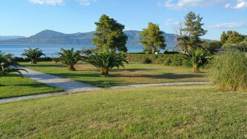 a walkway through a park with a view of the water at Beachfront Villa Tranquility in Longós