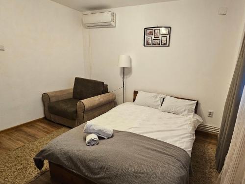 a hotel room with a bed and a chair at Cozy Studio in Brăila