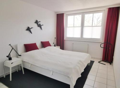 a bedroom with a white bed and a window at Apartmentvermittlung Mehr als Meer - Objekt 18 in Niendorf