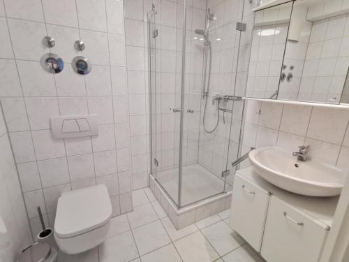 a bathroom with a shower and a toilet and a sink at Apartmentvermittlung Mehr als Meer - Objekt 18 in Niendorf