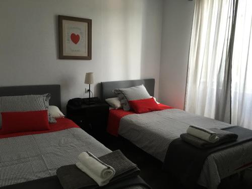 1 dormitorio con 2 camas y toallas. en Apartamentos cercanos playa, en Puentedeume