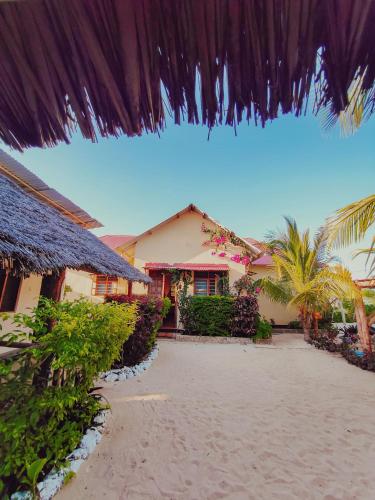 a house on the beach next to a beach at Tofauti Inn in Makunduchi