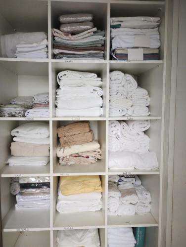 un armadio pieno di asciugamani bianchi di Recanto da Sol a Florianópolis