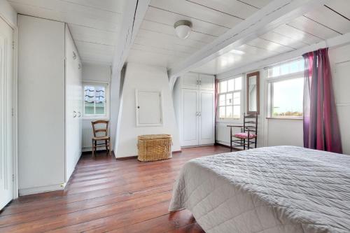 um quarto com uma cama, uma mesa e cadeiras em Pakhuys bij de Zaanse Schans em Zaandijk