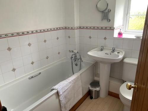 a bathroom with a tub and a sink and a toilet at Copley House in Richmond