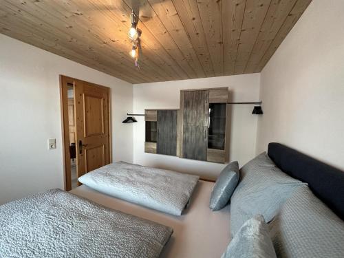um quarto com 2 camas e um tecto de madeira em Apartment Troger em Fieberbrunn
