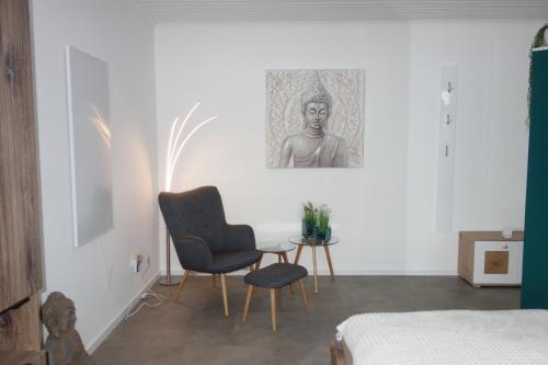 a bedroom with a chair and a table and a picture at Ferienwohnung Solling Niedersachsen in Uslar