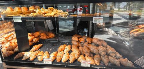 a display case in a bakery with lots of pastries at Benett apartman in Budapest