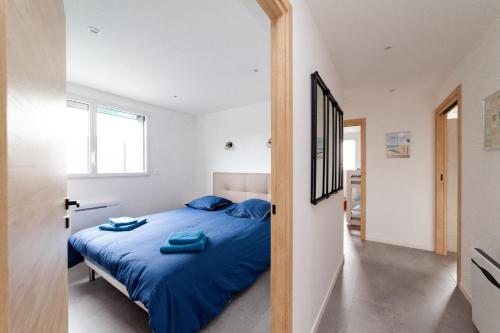 une chambre avec un lit avec des draps bleus et une fenêtre dans l'établissement Villa Belle Vue Le Tréport - familiale et spacieuse, au Tréport