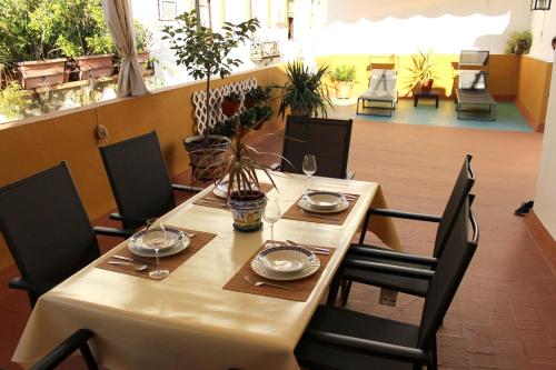 un tavolo in un ristorante con sedie e tavolo di Duplex acogedor con gran terraza en pleno centro de Sevilla! a Siviglia