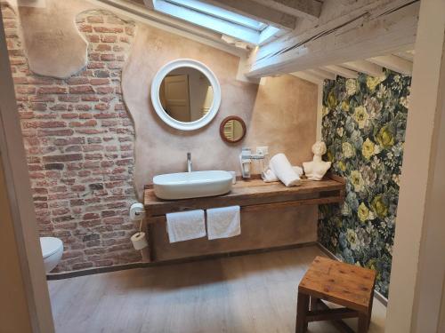 a bathroom with a sink and a brick wall at Inside the Wall in Lucca