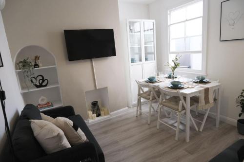 uma sala de estar com uma mesa e uma sala de jantar em Stylish 4 Bed Home in Aylesbury, Buckinghamshire em Buckinghamshire