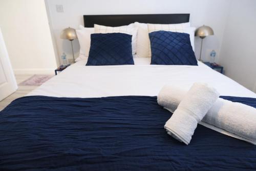 a bedroom with a large bed with towels on it at Stylish 4 Bed Home in Aylesbury, Buckinghamshire in Buckinghamshire