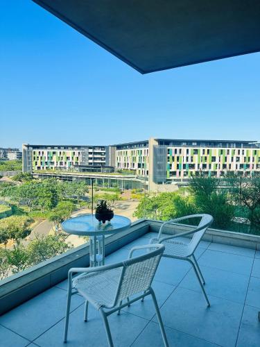a balcony with a table and chairs and a view of buildings at Ocean Dunes Bachelor Apartments in Umhlanga