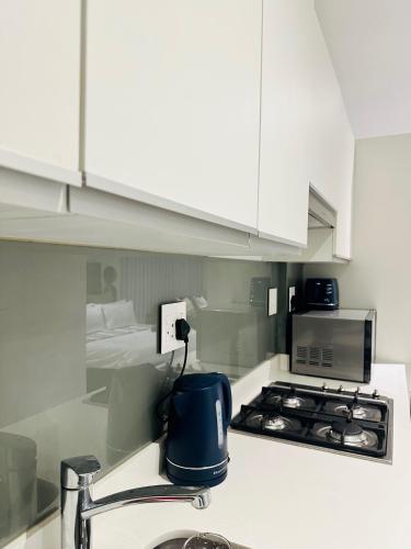 a kitchen with a sink and a stove top oven at Ocean Dunes Bachelor Apartments in Umhlanga