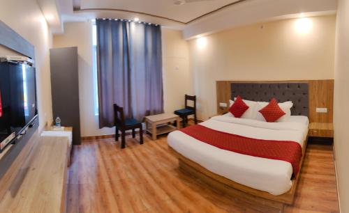 a hotel room with a large bed and a television at The Fragrance Hotel in Katra