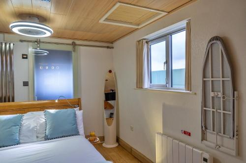 Schlafzimmer mit einem Bett und einem Surfbrett in der Unterkunft Finest Retreats - Treknow Summerhut in Tintagel