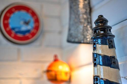 a bottle in front of a wall with a clock at Finest Retreats - Treknow Summerhut in Tintagel