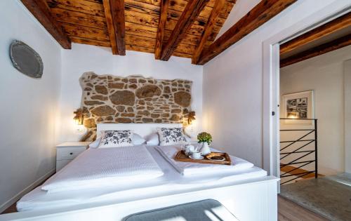 a bedroom with a large bed and wooden ceilings at House Filumena in Lopar