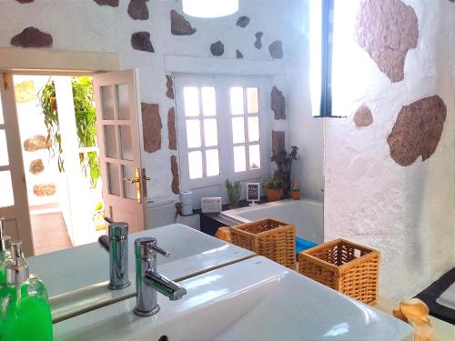 a white bathroom with a sink and a tub at Holy House in Santa Brígida