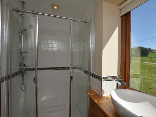 a bathroom with a glass shower and a sink at 1 Bed in Knighton 58997 in Whitton