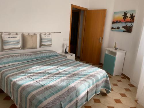 una camera da letto con un letto con un piumone a righe di Noto…sul mare! a Noto Marina