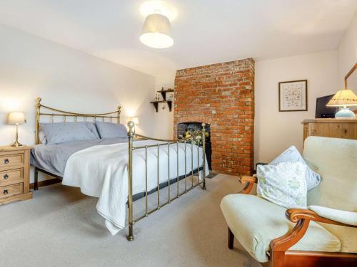 a bedroom with a bed and a brick wall at 3 bed in Carisbrooke IC037 in Newport