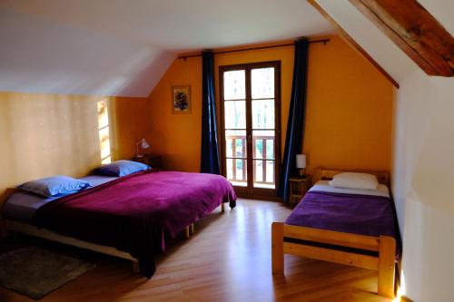 sypialnia z 2 łóżkami i oknem w obiekcie La Tourelle w mieście Pullay
