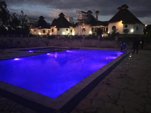 a swimming pool with blue lighting in front of a house at TURACO INTERCOUNTY RESORT in Maragoli