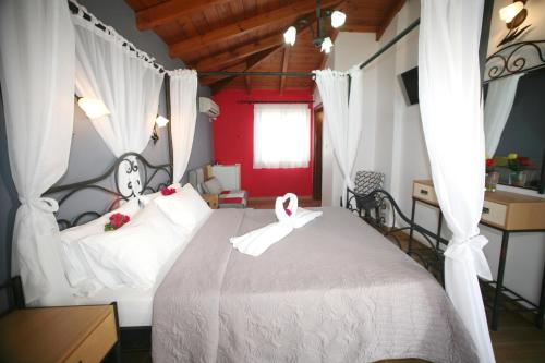 a bedroom with a bed with two swans on it at Coralli Rooms & Restaurant in Elafonisos