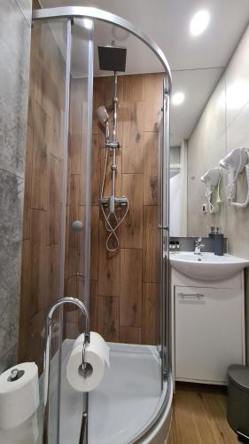 ein Bad mit einer Dusche und einem Waschbecken in der Unterkunft Apartament SECONDO 
