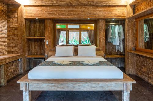 a bedroom with a bed in a wooden room at Jawa House Private Villas in Gili Trawangan