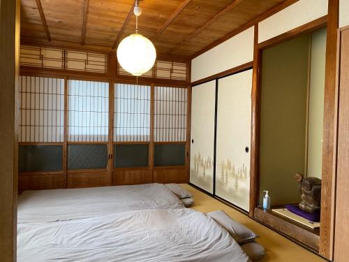 a bedroom with a bed in a room with windows at かげやんのいえ　KAGEYAN NO IE in Tsu