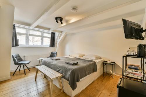 Un dormitorio con una cama y un televisor. en Amsterdam Alley Apartment, en Ámsterdam