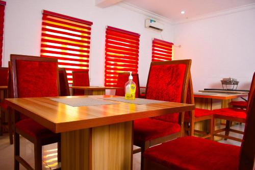 a dining room with red shutters and a table and chairs at Roses Regency Hotel in Abuja