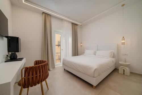 biała sypialnia z białym łóżkiem i oknem w obiekcie Unico w mieście Sassari