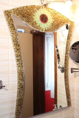 a mirror with a sunflower on top of it at Coralli Rooms & Restaurant in Elafonisos