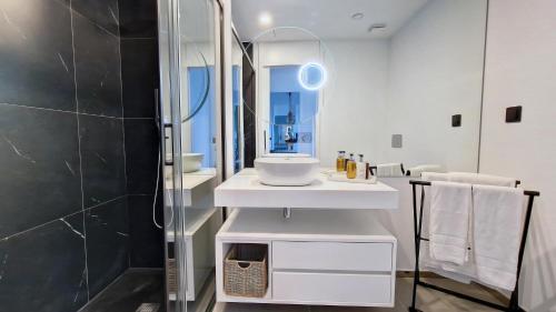 uma casa de banho com um lavatório e um espelho em Roots Loft by LovelyStay em Funchal