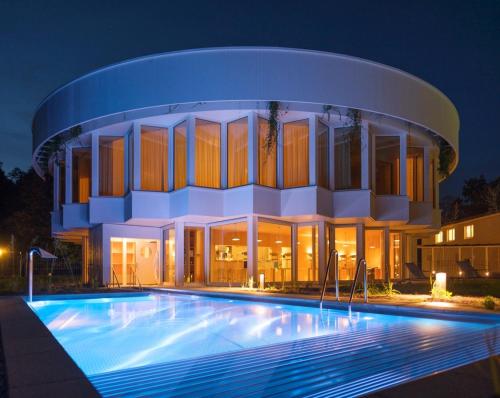 a building with a swimming pool at night at Hotel Hof Weissbad in Weissbad