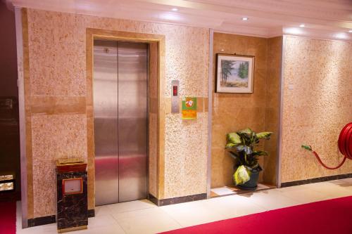 an elevator in a building with a plant at Tiffany Diamond Hotels Ltd - Indira Gandhi street in Dar es Salaam