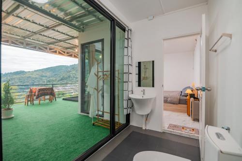 baño con vistas a un suelo verde en ม่านเขาโฮมสเตย์Mankhao Homestay บ้านกระจก, 