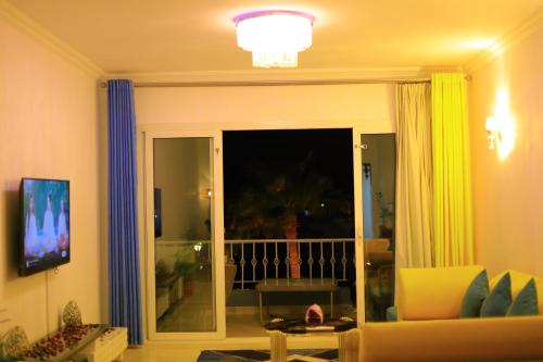 sala de estar con una puerta corredera de cristal que da a un balcón en New Marina Hurghada Suite en Hurghada