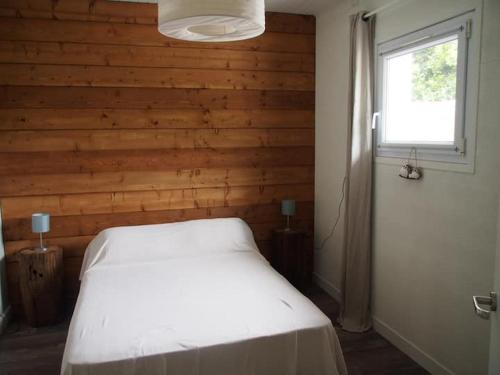 1 dormitorio con cama blanca y ventana en Charmant T2 avec piscine entre mer et montagne en Ibarron