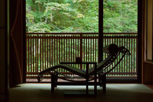 a rocking chair sitting in front of a window at Futari Shizuka in Komagane