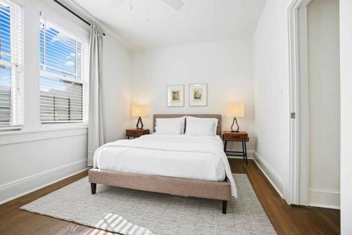 a white bedroom with a large bed and two windows at Cozy Apartment in Virginia Highland in Atlanta