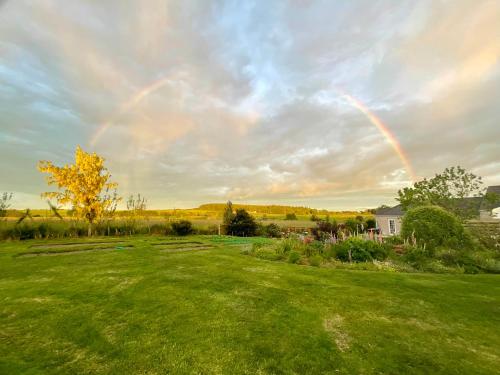 un arco iris en el cielo sobre un patio verde en The Wee Hoose, en Dumfries