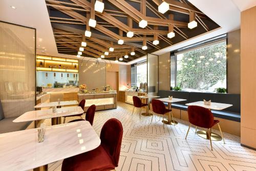 um restaurante com mesas e cadeiras e uma cafetaria em Atour Light Hotel Shenyang Tiexi Plaza Wanxianghui em Shenyang