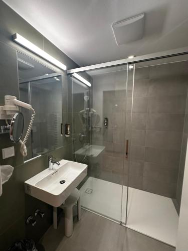 a bathroom with a glass shower and a sink at Hotel & Restaurant Graf in Sankt Pölten
